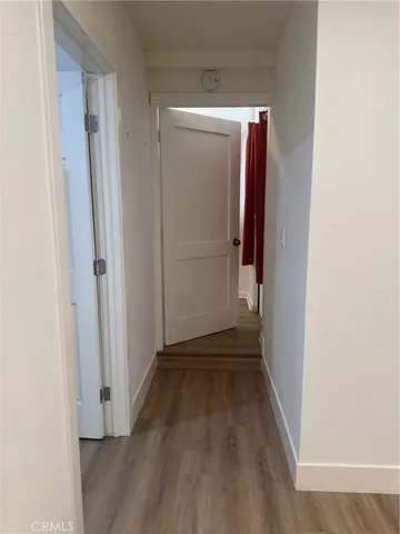 a view of a hallway with wooden floor