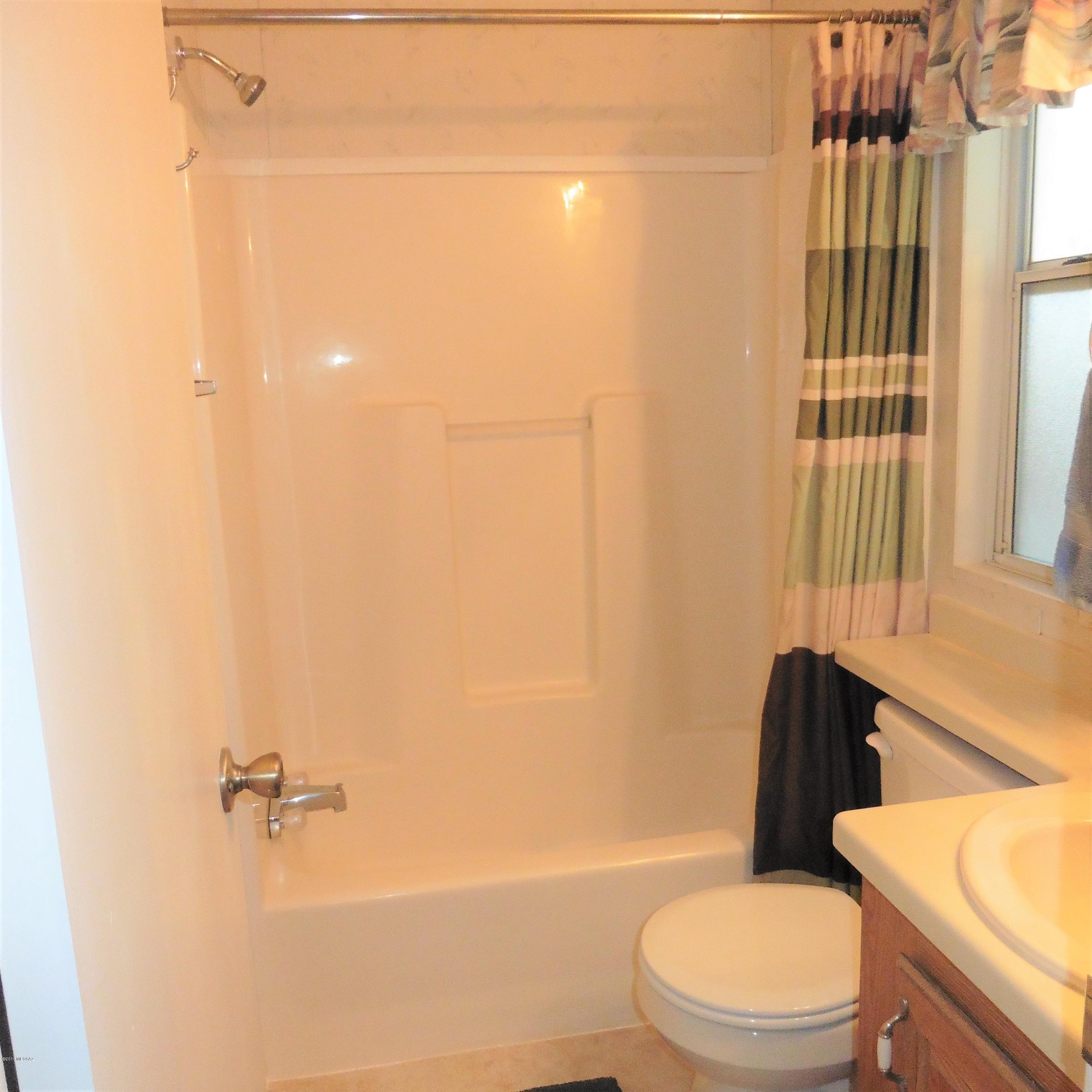 4906 West Massingale Road Tucson, AZ 85741 - Photo 16 of 17 a white toilet sitting next to a bath tub