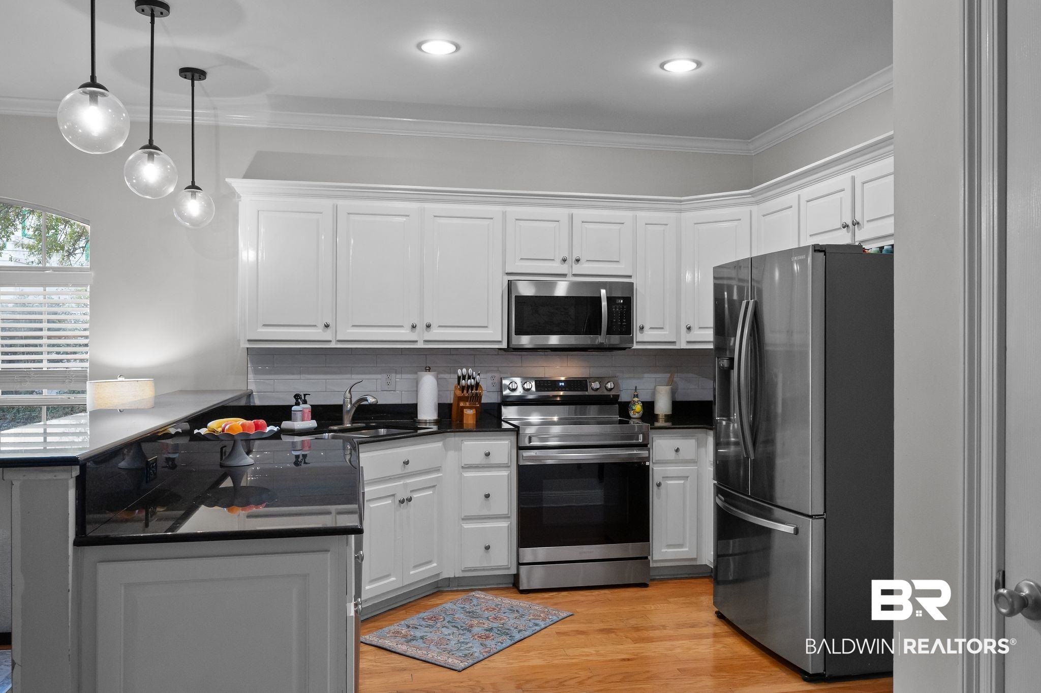 1825 Spring Hill Avenue Mobile, AL 36607 - Photo 13 of 43 Kitchen with a peninsula, stainless steel appliances, white cabinetry, pendant lighting, and dark stone countertops