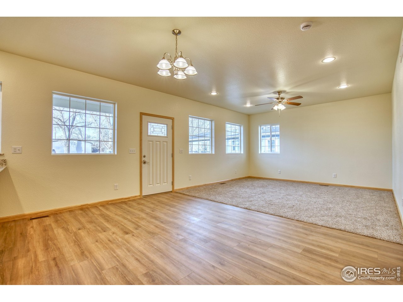 126 2nd Street Mead, CO 80542 - Photo 11 of 22 an empty room with wooden floor and windows