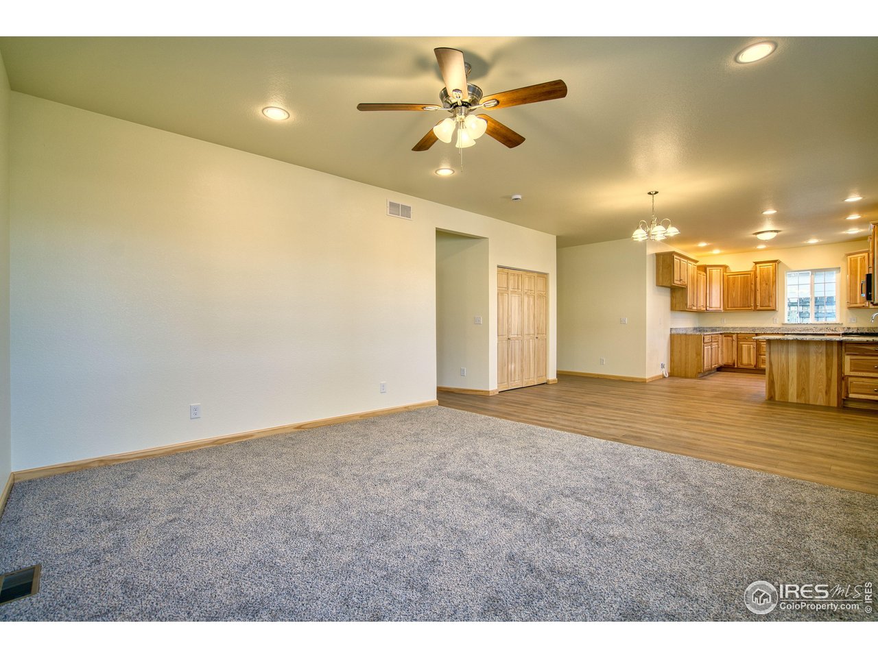 126 2nd Street Mead, CO 80542 - Photo 6 of 22 a view of an empty room and kitchen with furniture and a ceiling fan