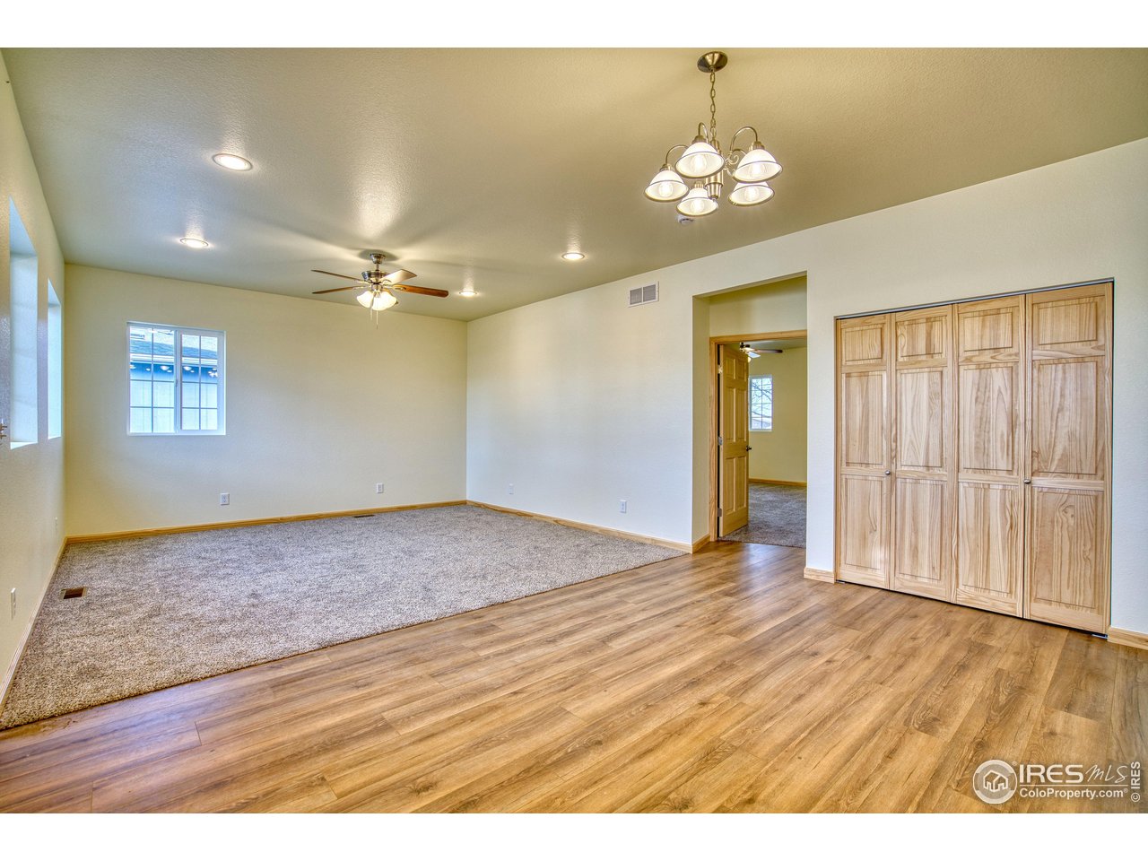 126 2nd Street Mead, CO 80542 - Photo 7 of 22 a view of an empty room with a chandelier fan and kitchen view