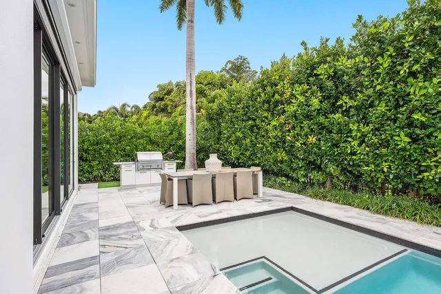 a front view of a house with a yard and palm trees