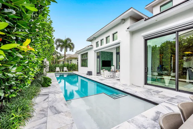 a view of a house with swimming pool and sitting area
