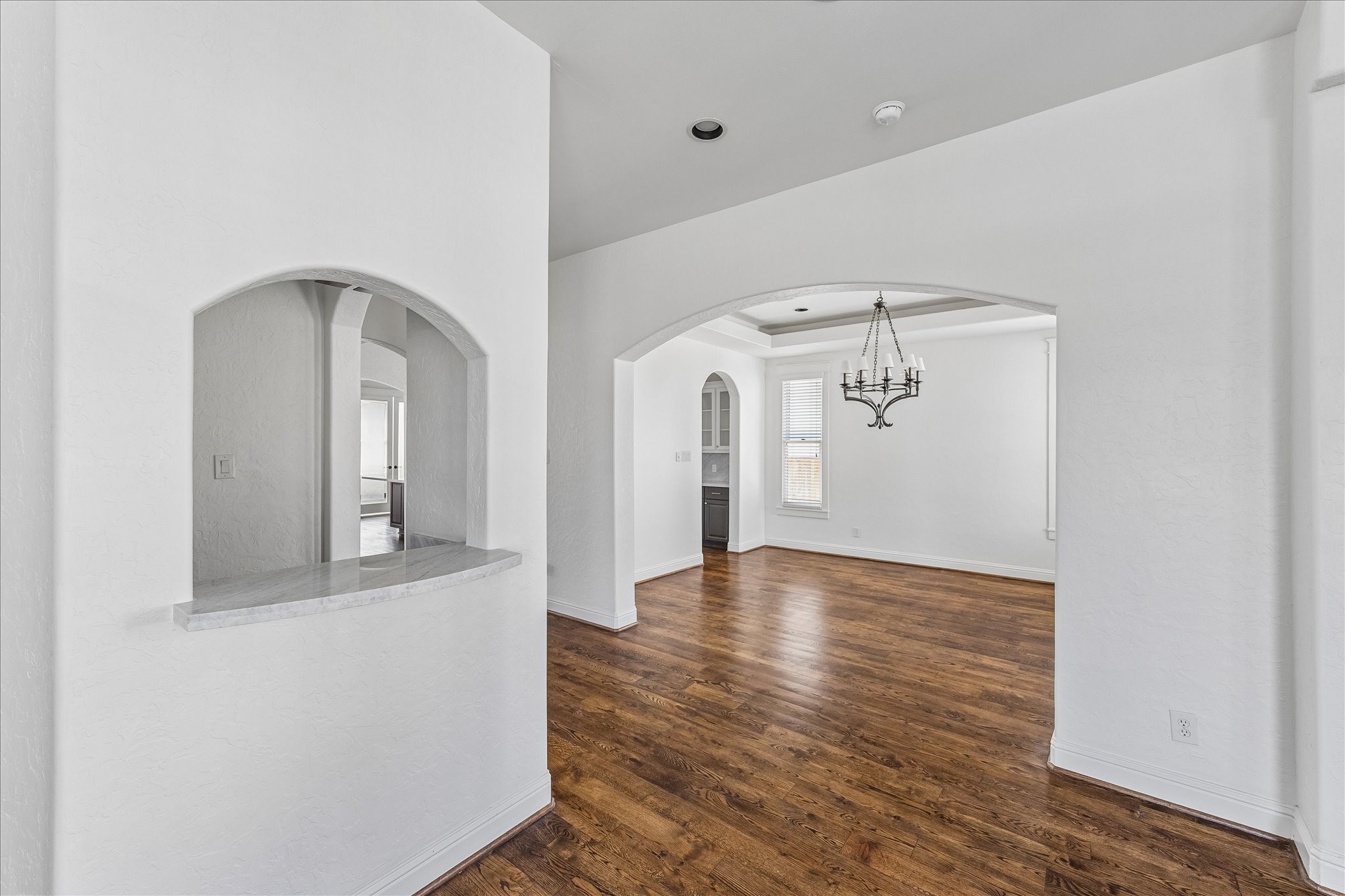 1408 West 23rd Street Houston, TX 77008 - Photo 11 of 40 Open sightlines from the entry highlight the home’s architectural arches and newly updated Carrara marble counters carried throughout the downstairs.