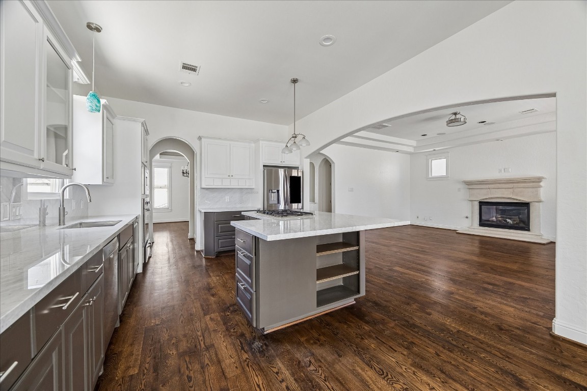 1408 West 23rd Street Houston, TX 77008 - Photo 17 of 40 Another view of the kitchen highlighting the spacious island with built-in shelving and seamless flow into the living area.