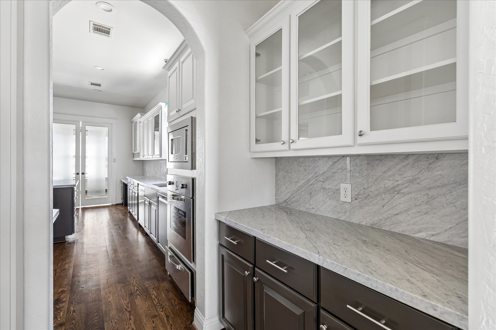 1408 West 23rd Street Houston, TX 77008 - Photo 18 of 40 Elegant butler’s pantry with built-in cabinetry, glass-front uppers, and Carrara marble counters and backsplash for additional prep and storage space.