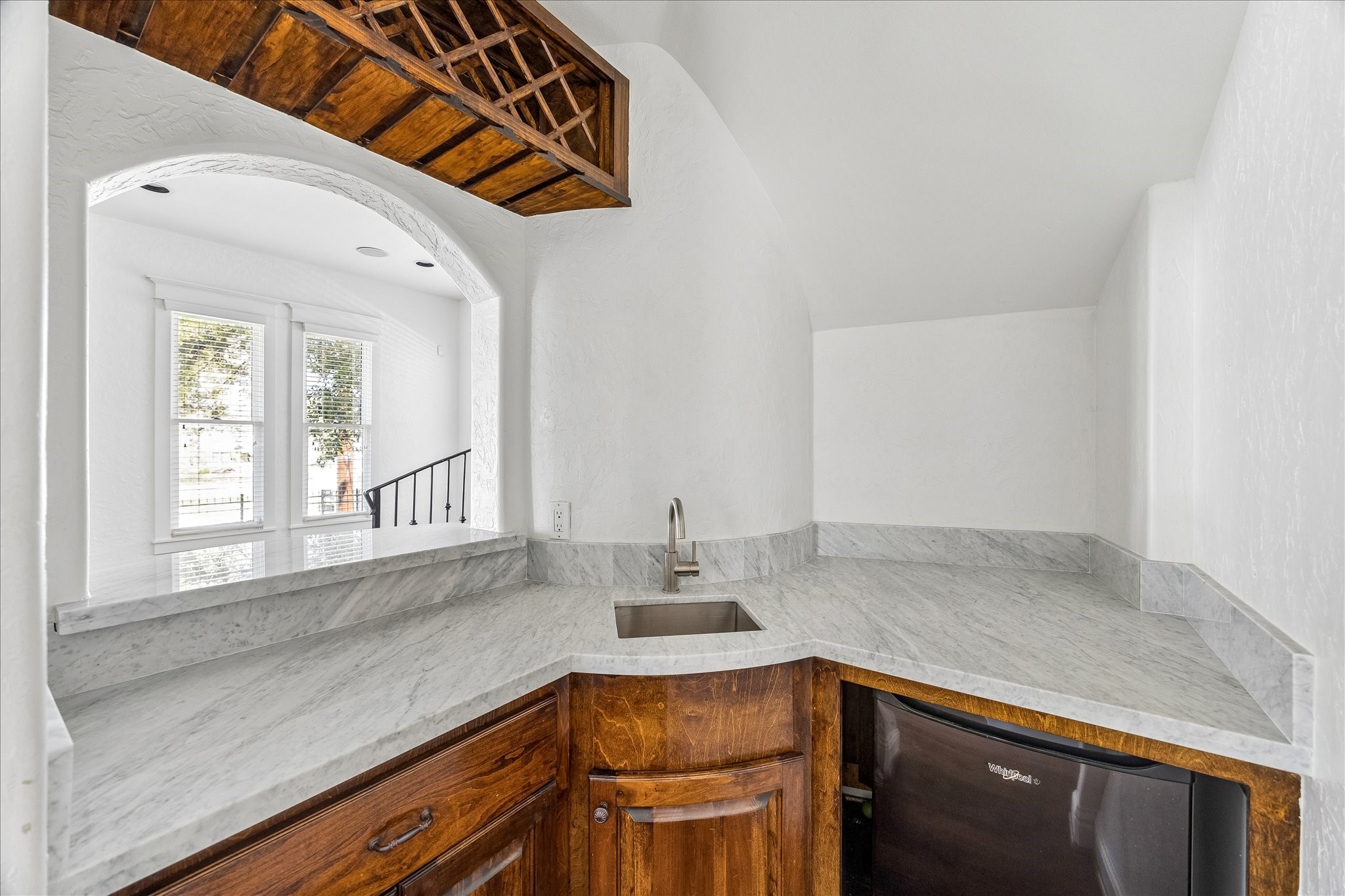 1408 West 23rd Street Houston, TX 77008 - Photo 20 of 40 Detailed view of the bar area with sink, marble surfaces, and mini fridge, with space ideal for a wine refrigerator.