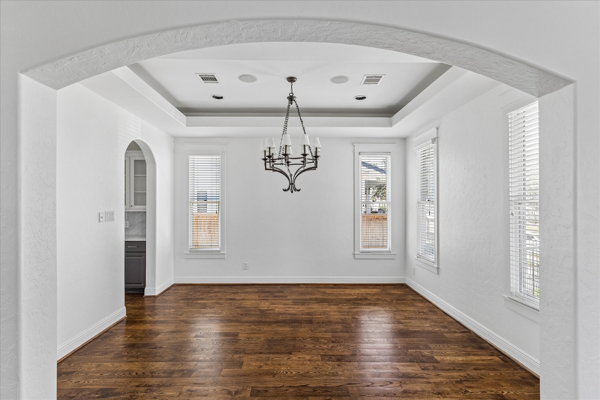 1408 West 23rd Street Houston, TX 77008 - Photo 2 of 40 Elegant formal dining room with tray ceiling, arched entry, and rich hardwood floors.