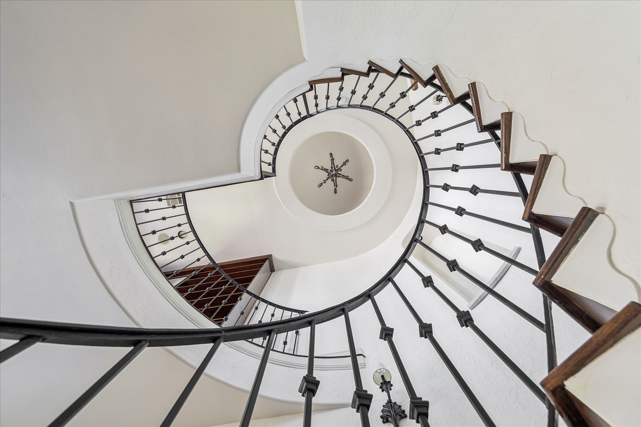 1408 West 23rd Street Houston, TX 77008 - Photo 24 of 40 Striking view looking up the curved staircase highlighting the circular ceiling detail and statement chandelier.