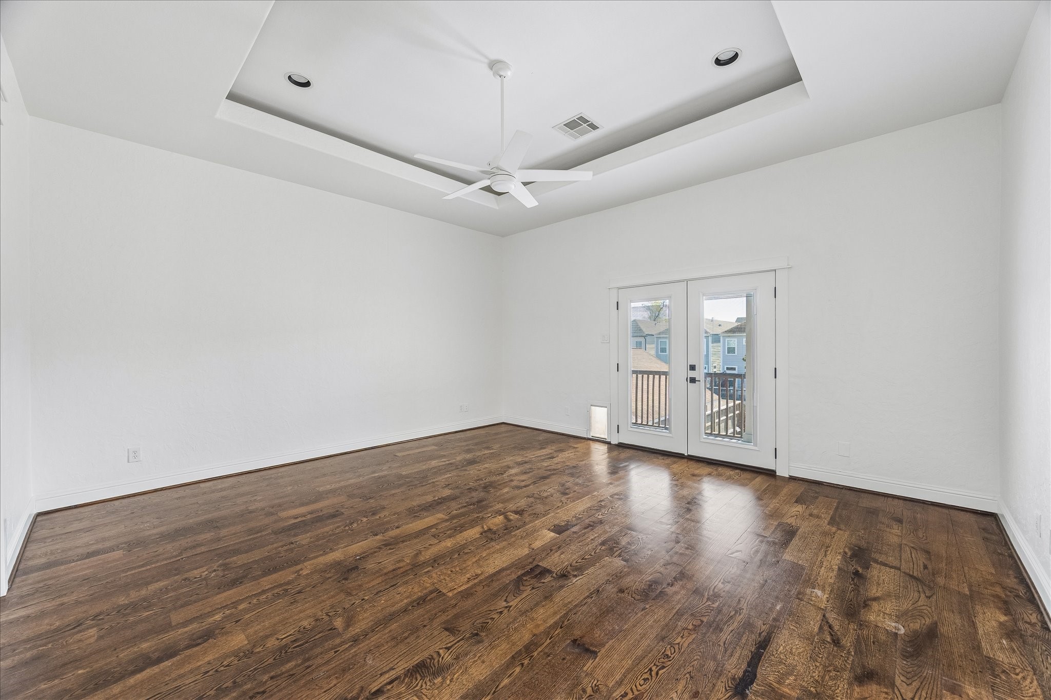 1408 West 23rd Street Houston, TX 77008 - Photo 26 of 40 Generous primary suite with tray ceiling, hardwood floors, and double doors opening to a private balcony.