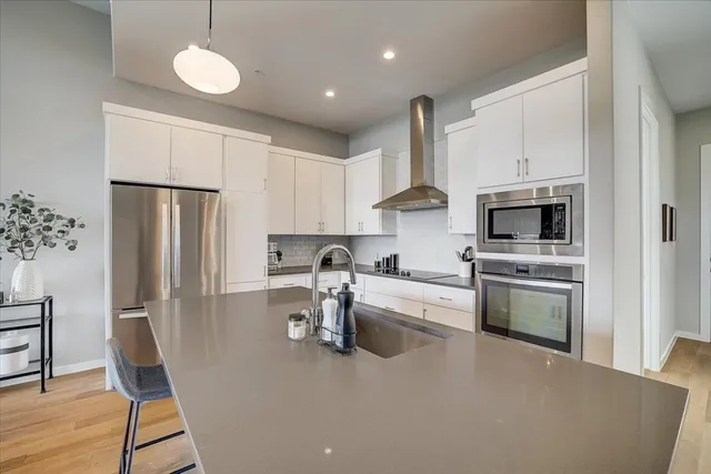a kitchen with refrigerator cabinets and wooden floor