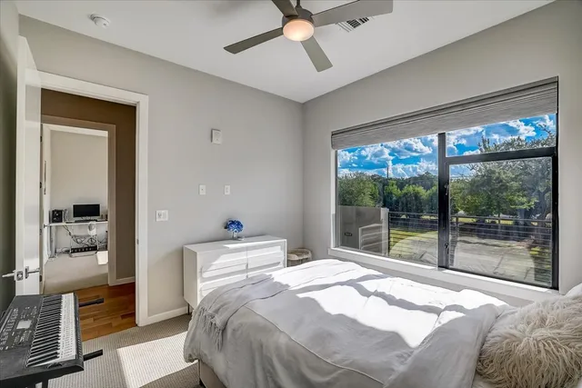 a bedroom with a bed and a large window with balcony view