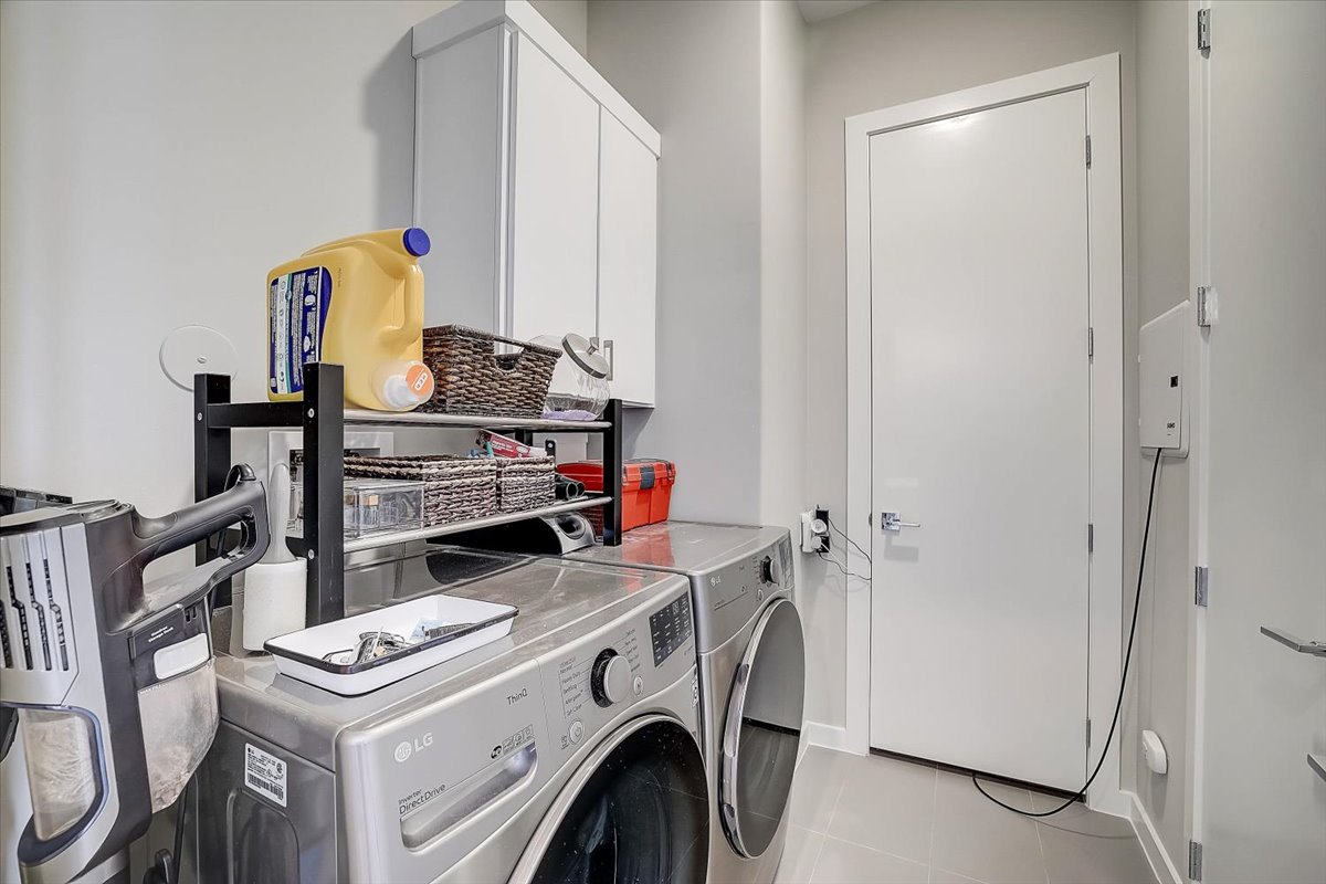 5921 Hiline Road, Unit 1204 Austin, TX 78734 - Photo 22 of 36 Laundry room with cabinet space, washing machine and clothes dryer, and light tile patterned floors