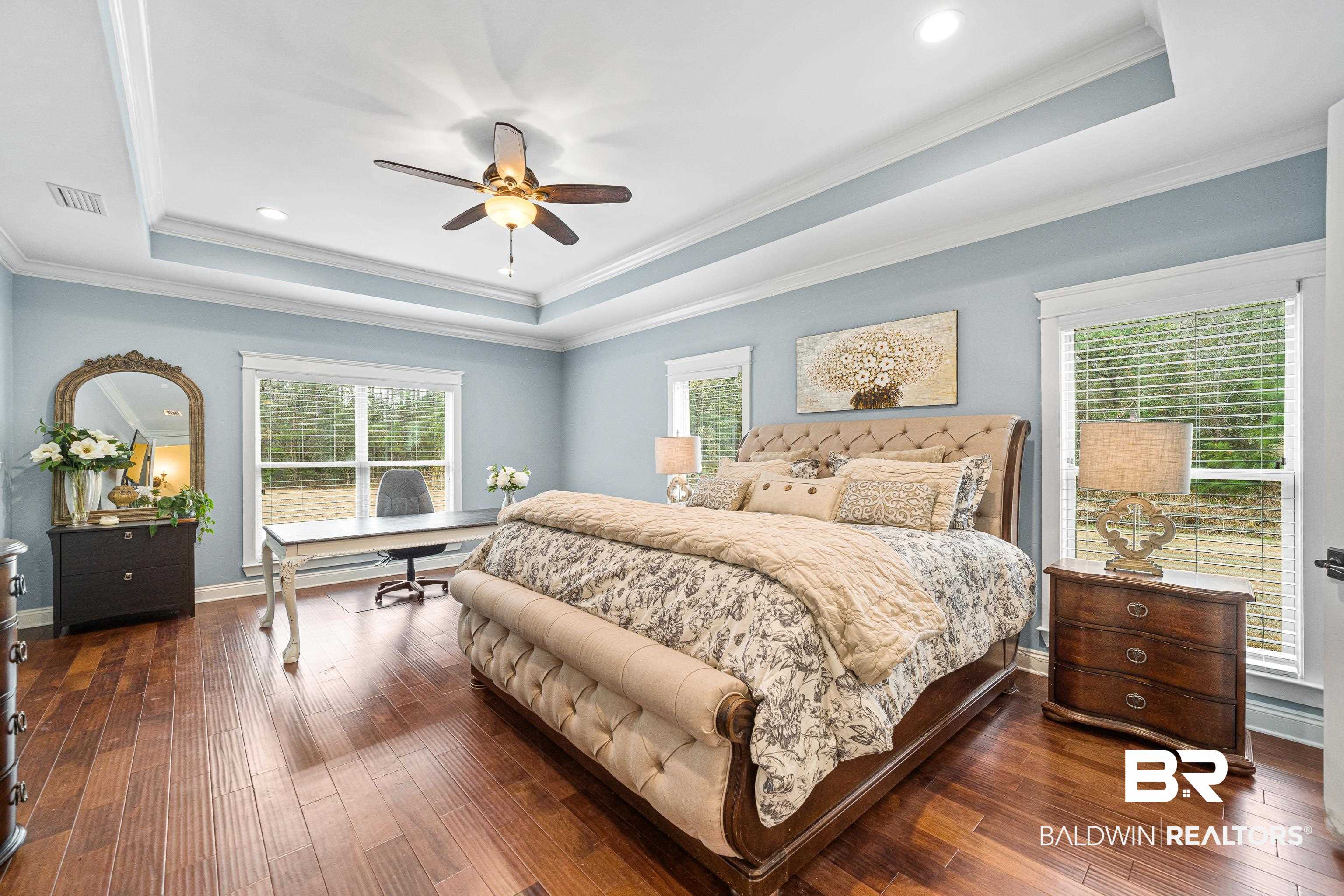 36784 Legacy Way Bay Minette, AL 36507 - Photo 22 of 57 Oversized Primary Bedroom with wood-style floors, sitting/office area, a raised ceiling, lots of natural light and door leading to the covered patio.