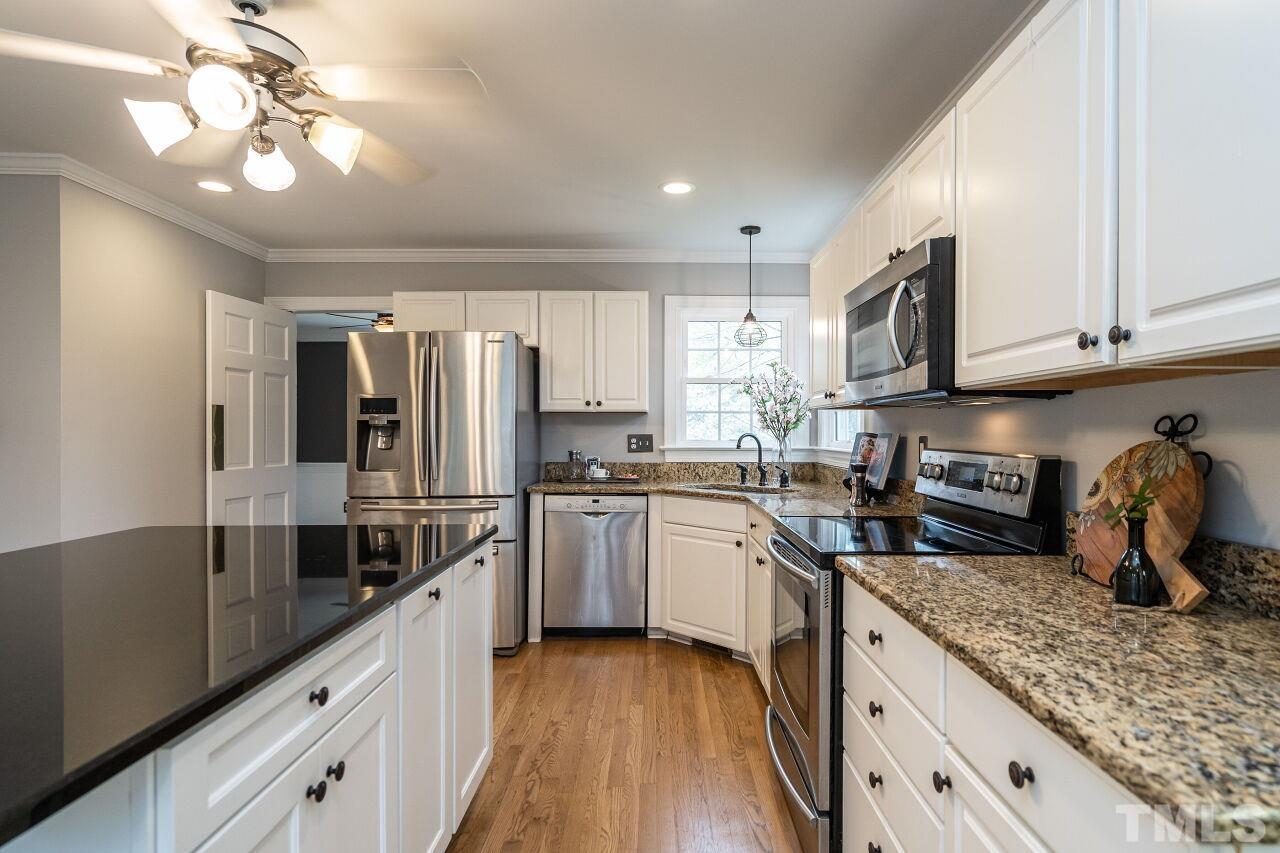 107 Needle Park Drive Cary, NC 27513 - Photo 11 of 29 a kitchen with stainless steel appliances granite countertop a sink refrigerator and cabinets