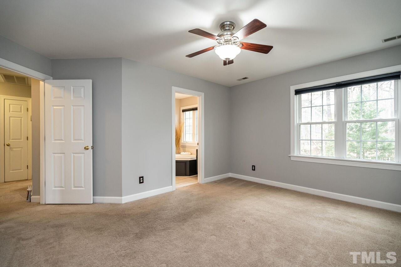 107 Needle Park Drive Cary, NC 27513 - Photo 15 of 29 an empty room with chandelier fan and windows