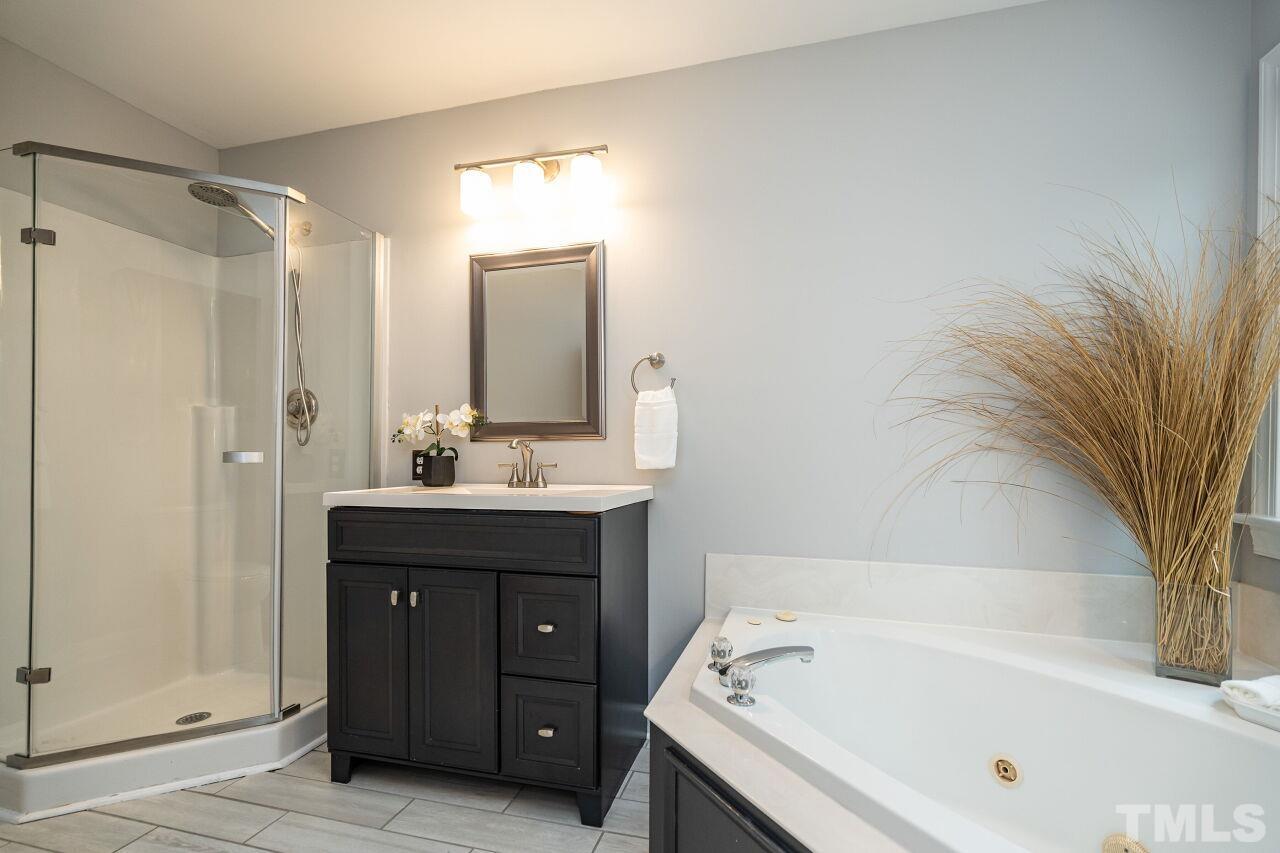 107 Needle Park Drive Cary, NC 27513 - Photo 17 of 29 a bathroom with a tub sink and mirror
