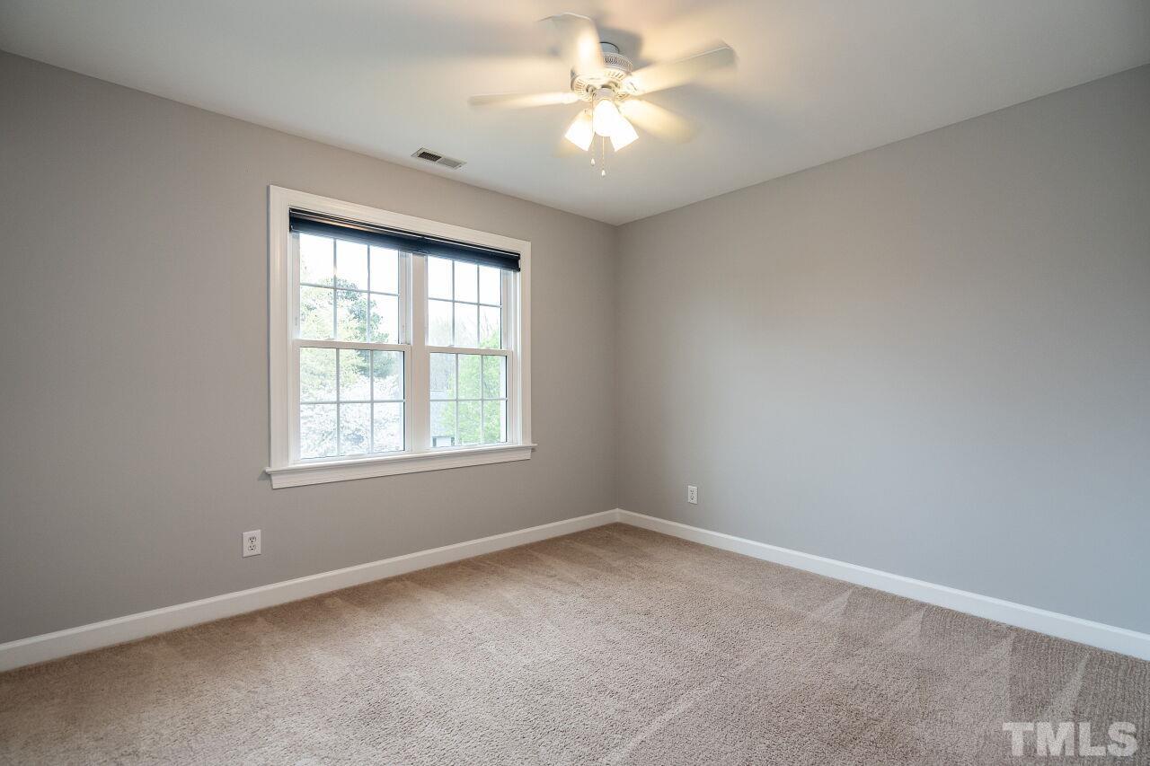 107 Needle Park Drive Cary, NC 27513 - Photo 18 of 29 an empty room with a window and a fan
