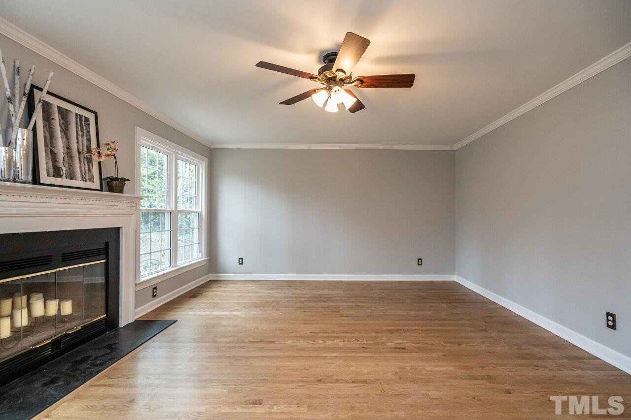 107 Needle Park Drive Cary, NC 27513 - Photo 7 of 29 a view of an empty room with wooden floor and a fireplace