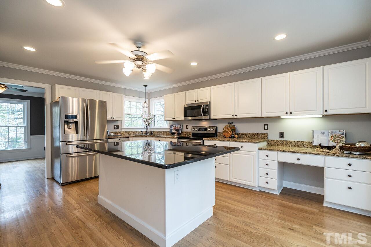 107 Needle Park Drive Cary, NC 27513 - Photo 10 of 29 a kitchen with stainless steel appliances granite countertop a stove top oven a sink dishwasher a refrigerator and white cabinets with wooden floor