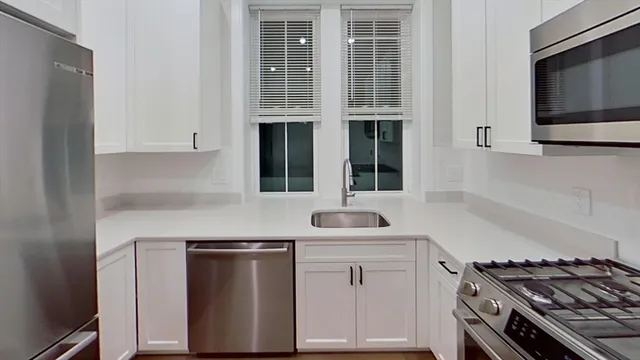 a kitchen with stainless steel appliances granite countertop a sink and a stove