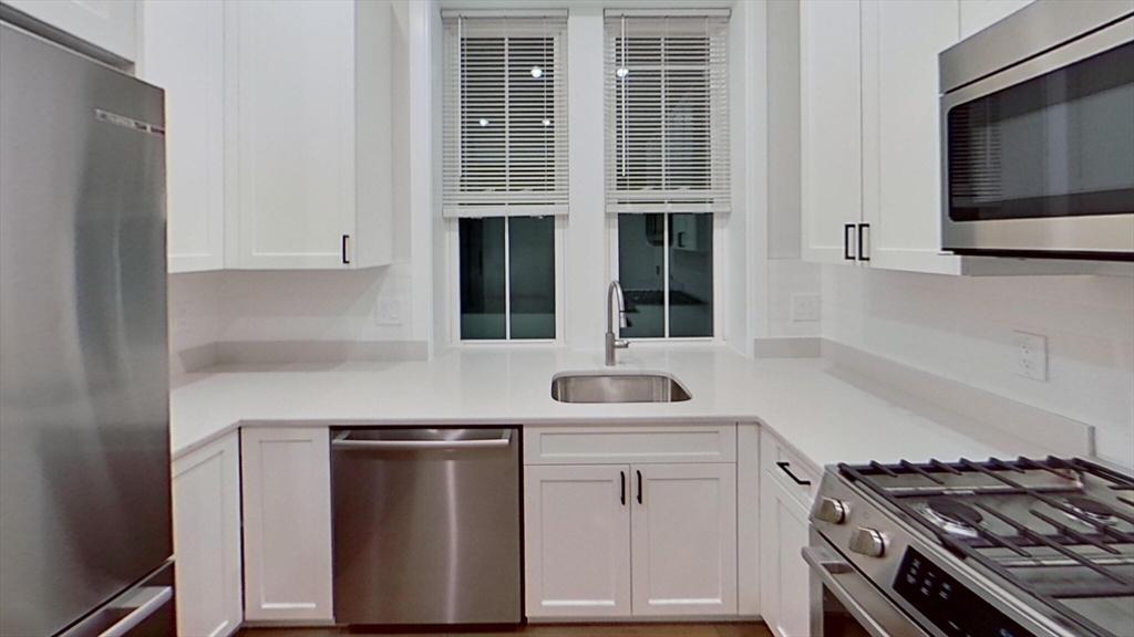47 Englewood Avenue, Unit 1 Boston, MA 02135 - Photo 1 of 5 a kitchen with stainless steel appliances granite countertop a sink and a stove