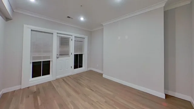 an empty room with wooden floor and fireplace