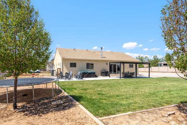 7776 Wagon Road East St. George, UT 84770 - Photo 50 of 76 Rear view of property with a patio area, stucco siding, a fenced backyard, and a trampoline