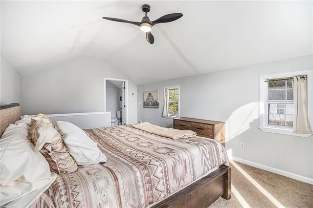 a bedroom with a bed ceiling fan and a window
