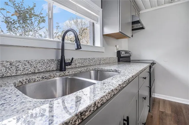 a view of a kitchen sink with granite countertop a plate of food on it