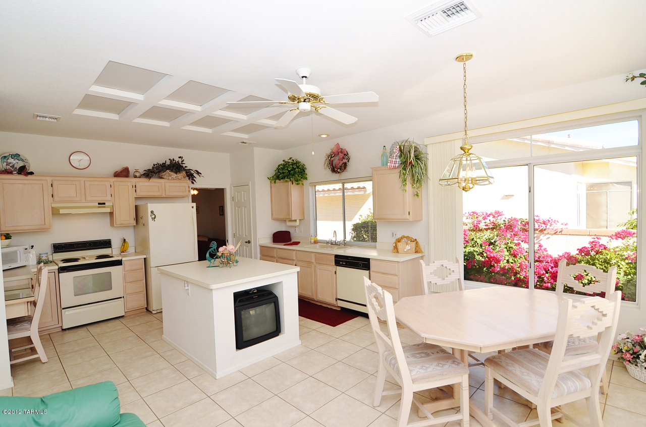 1330 East Crown Ridge Drive Tucson, AZ 85755 - Photo 4 of 22 a kitchen that has a stove a table and chairs in it