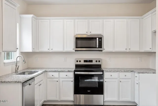 an empty room with chandelier fan and windows