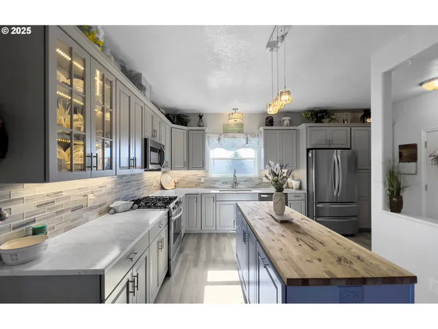 a kitchen with kitchen island granite countertop lots of counter top space and stainless steel appliances
