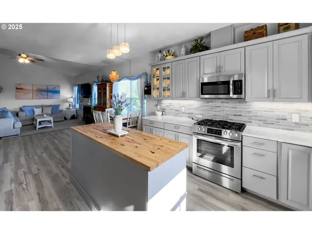 a kitchen with stainless steel appliances kitchen island granite countertop a sink dishwasher stove and oven with wooden floor