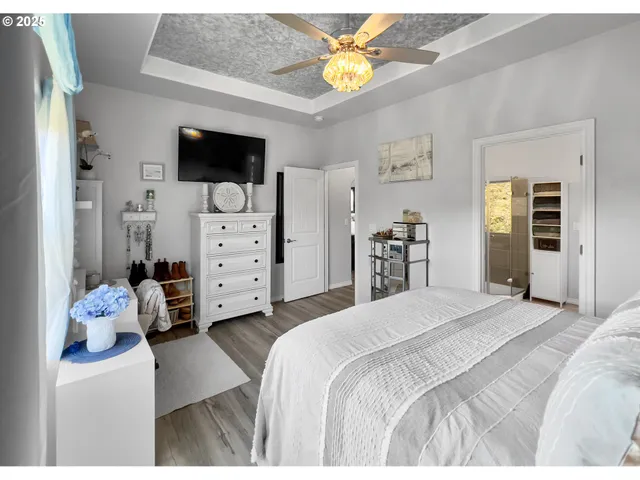 a bedroom with a bed and a flat tv screen on dresser