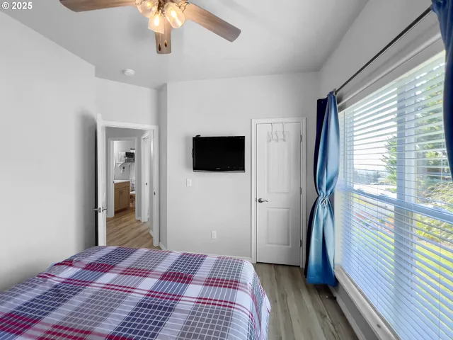 a view of a bedroom with wooden floor fan and window