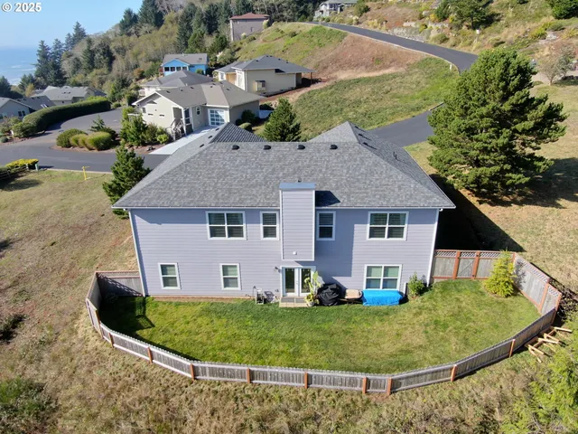an aerial view of a house with a yard and trees