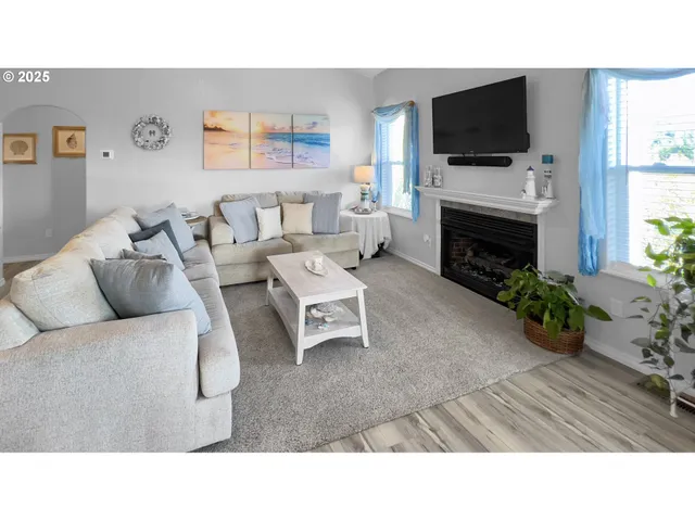 a living room with furniture a flat screen tv and a fireplace