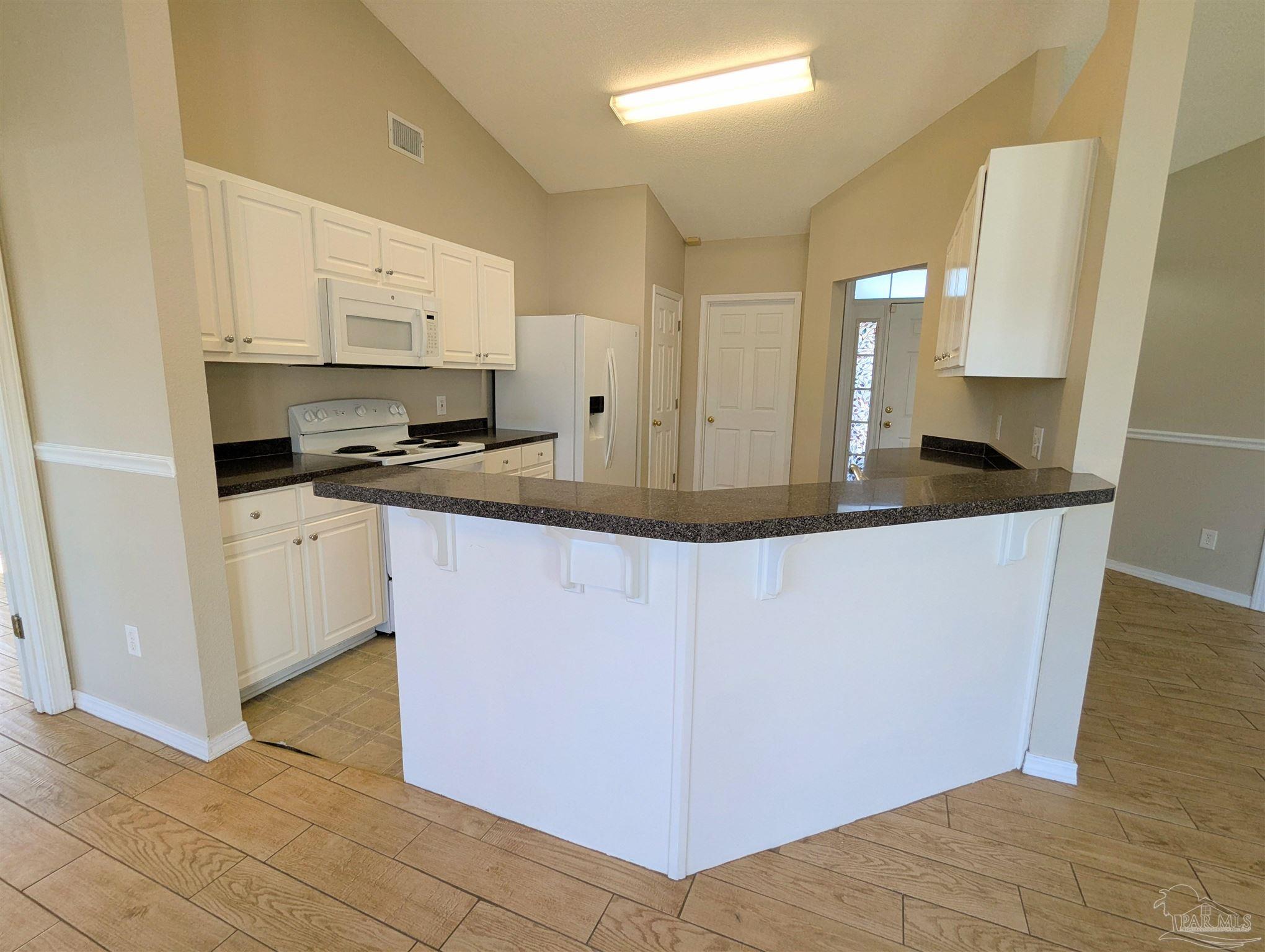 7108 Fitzpatrick Road Pensacola, FL 32526 - Photo 11 of 30 a kitchen with stainless steel appliances granite countertop a sink a stove a microwave a counter space and cabinets
