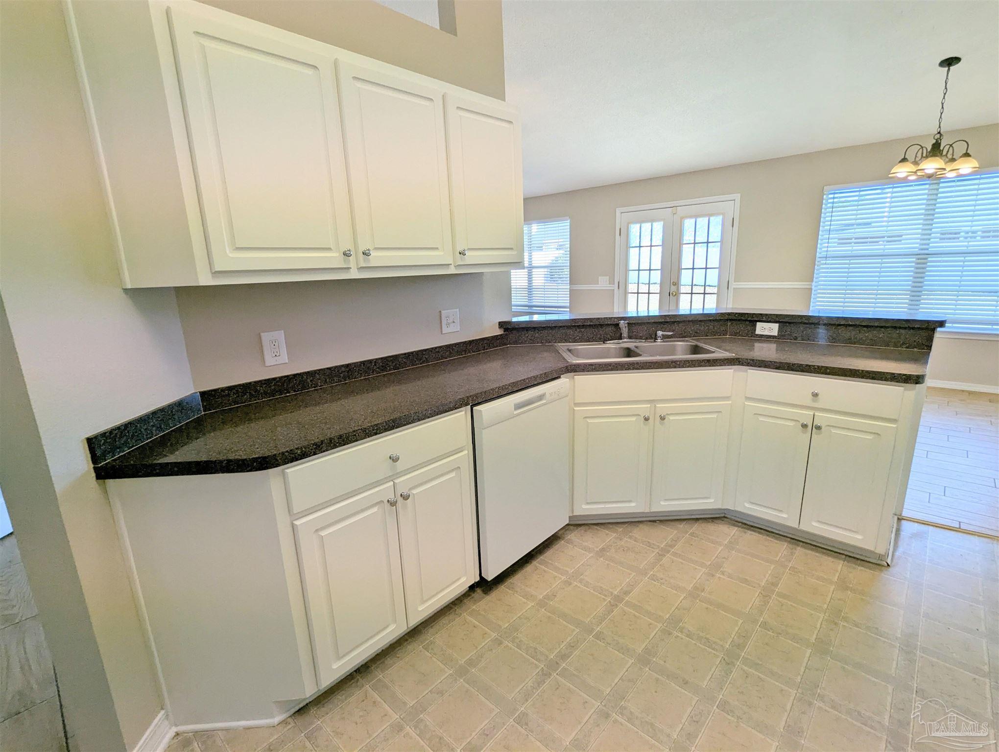 7108 Fitzpatrick Road Pensacola, FL 32526 - Photo 13 of 30 a kitchen with granite countertop white cabinets white appliances and sink