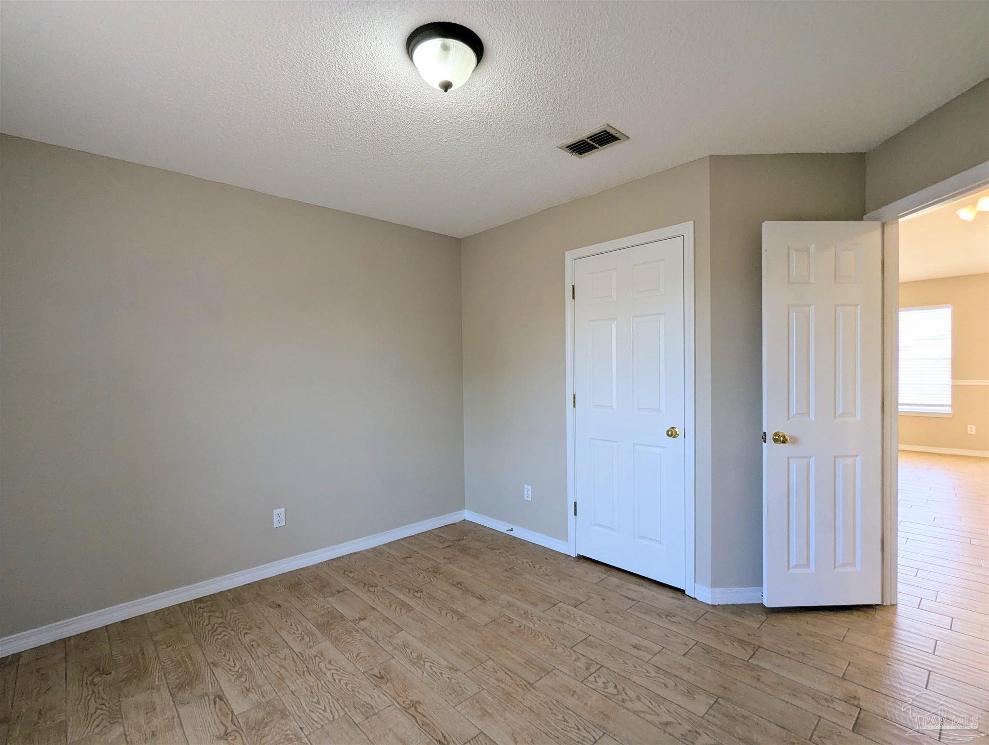 7108 Fitzpatrick Road Pensacola, FL 32526 - Photo 3 of 30 a view of an empty room and wooden floor