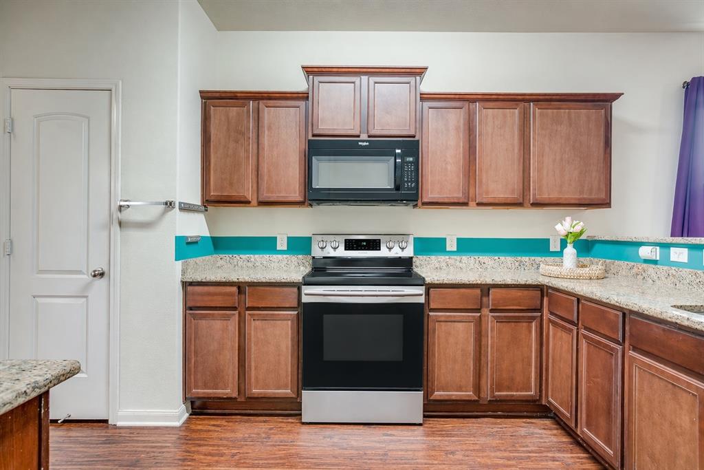 136 Kennedy Drive Venus, TX 76084 - Photo 3 of 27 a kitchen with granite countertop a sink and a stove top oven
