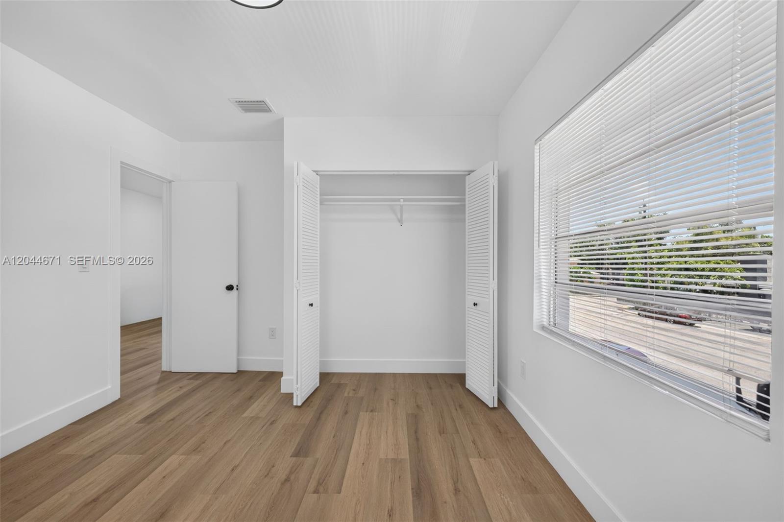 1900 Southwest 6th Street, Unit 6 Miami, FL 33135 - Photo 15 of 20 a view of an empty room with wooden floor and a window