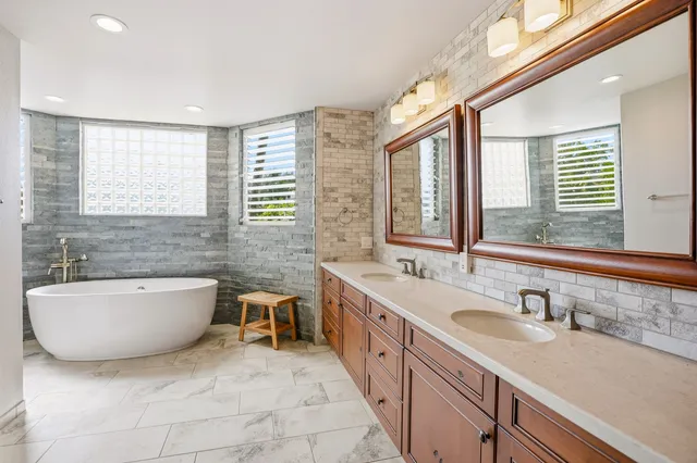a bathroom with a tub sink and mirror