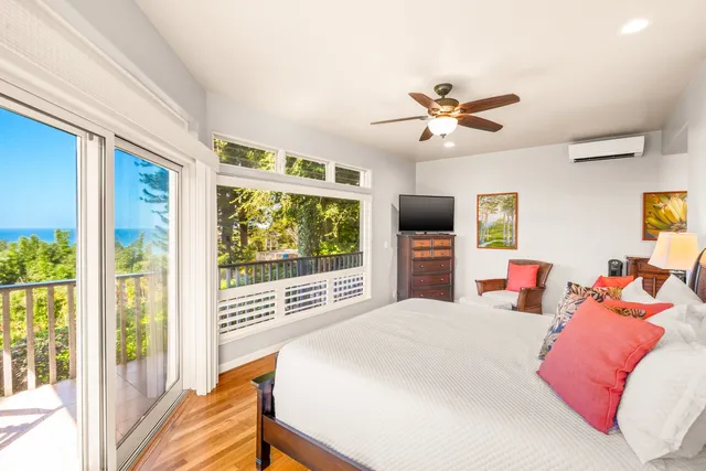 a bedroom with a large bed and a flat tv screen