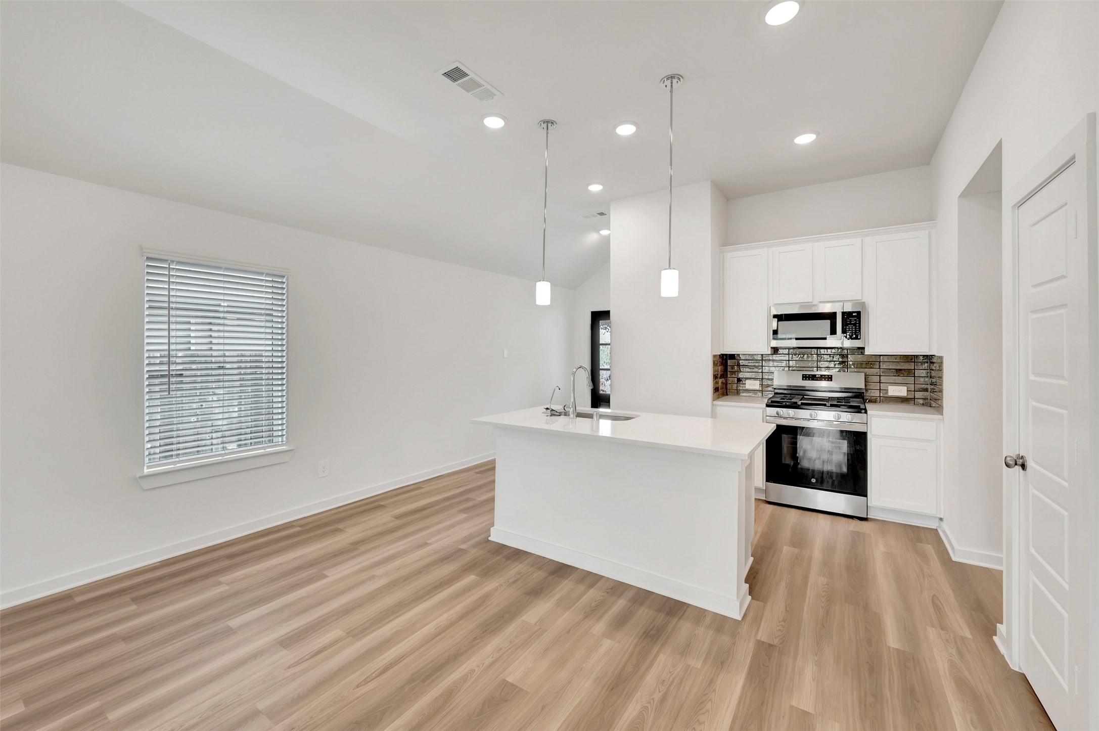543 Flower Reed Court Magnolia, TX 77354 - Photo 26 of 46 a kitchen with stainless steel appliances a stove top oven a sink dishwasher and a refrigerator with wooden floor