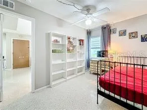 a bedroom with a bed chandelier and a window