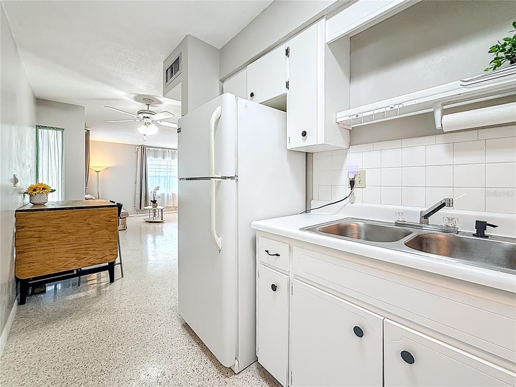 250 Rosery Road Northwest, Unit 283 Largo, FL 33770 - Photo 11 of 23 a kitchen with a sink a refrigerator and cabinets