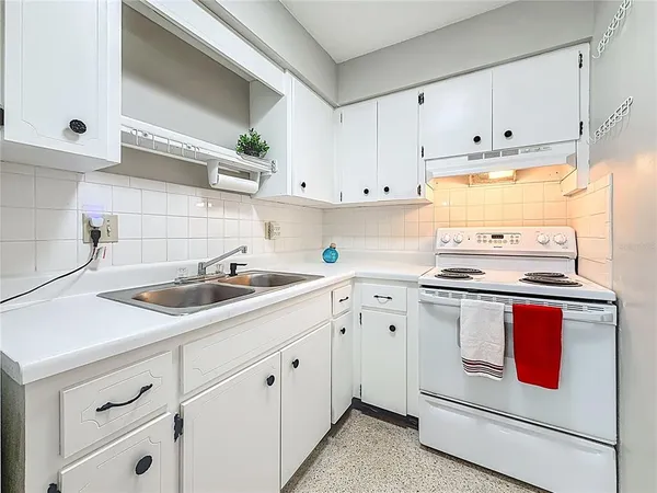 a kitchen with granite countertop white cabinets and white appliances